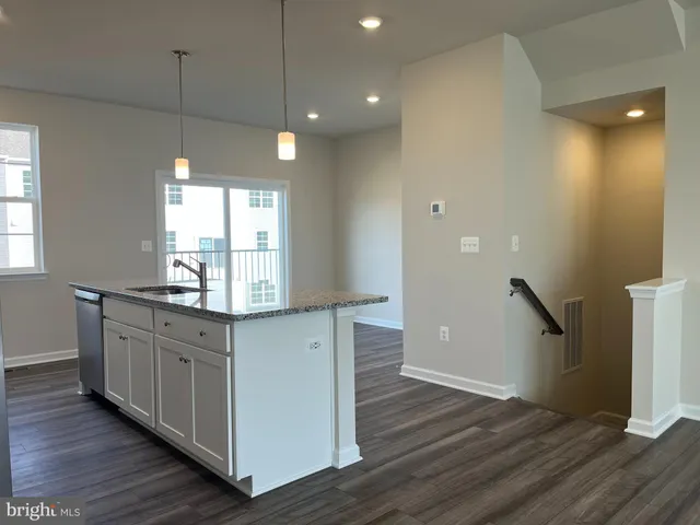a kitchen with granite countertop a stove and wooden floor