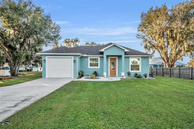 a front view of a house with a yard and trees