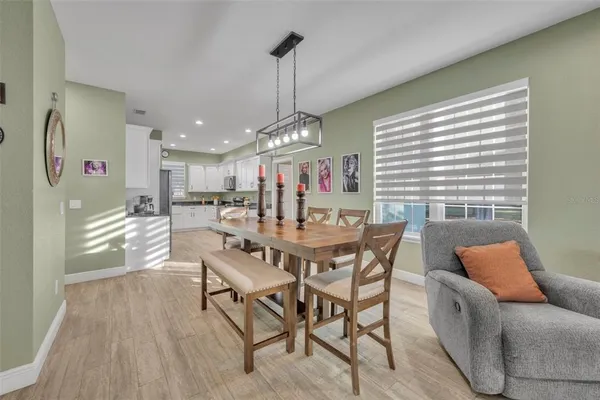 a view of a dining room and livingroom with furniture wooden floor a chandelier