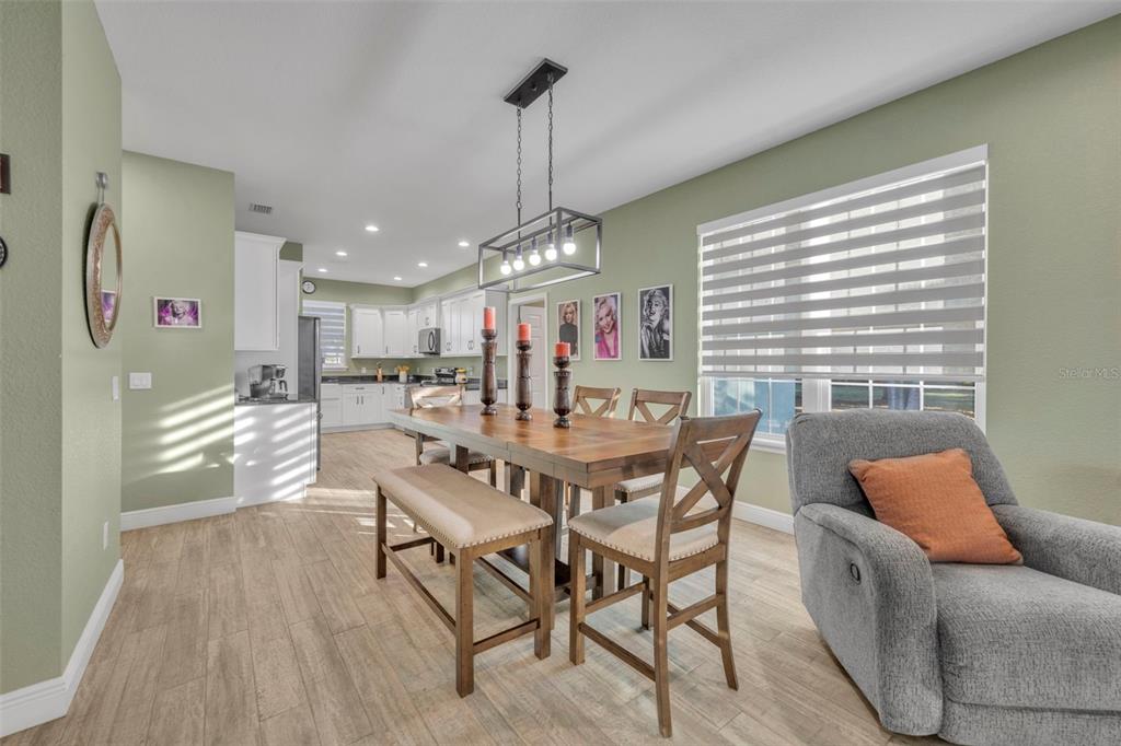 1947 North Lake Reedy Boulevard Frostproof, FL 33843 - Photo 11 of 31 a view of a dining room and livingroom with furniture wooden floor a chandelier