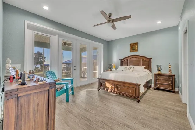 a bedroom with a bed a dresser and wooden floor