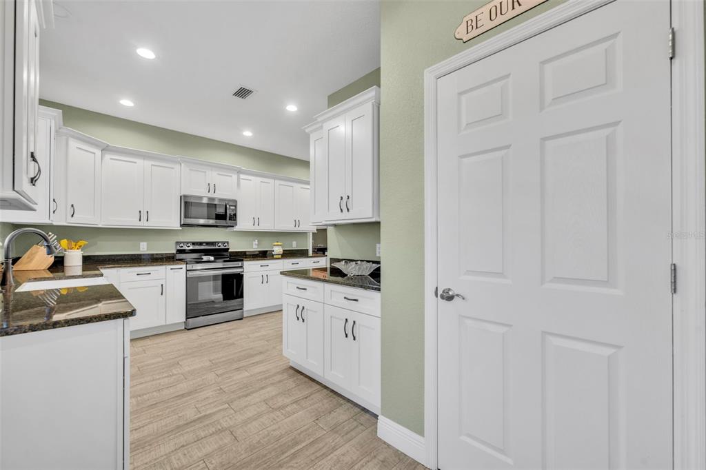 1947 North Lake Reedy Boulevard Frostproof, FL 33843 - Photo 6 of 31 a kitchen with granite countertop white cabinets and stainless steel appliances