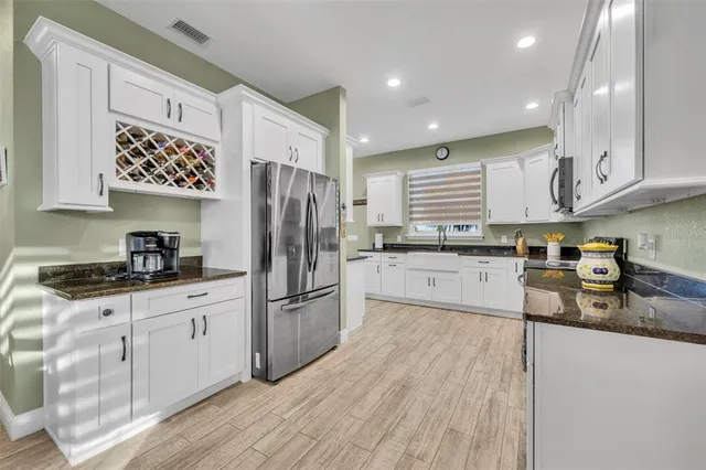 a kitchen with stainless steel appliances granite countertop a refrigerator sink and cabinets