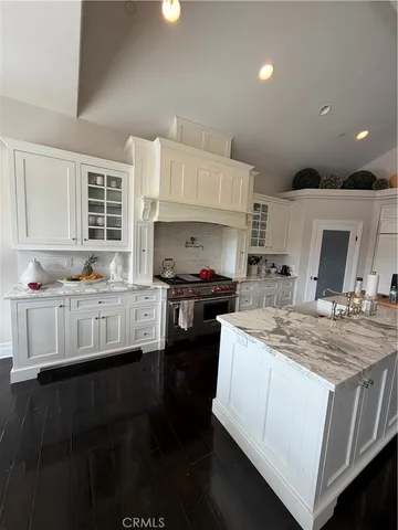 a kitchen with kitchen island granite countertop a stove and a sink