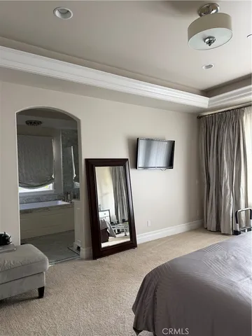 a bedroom with a bed and a mirror on dresser
