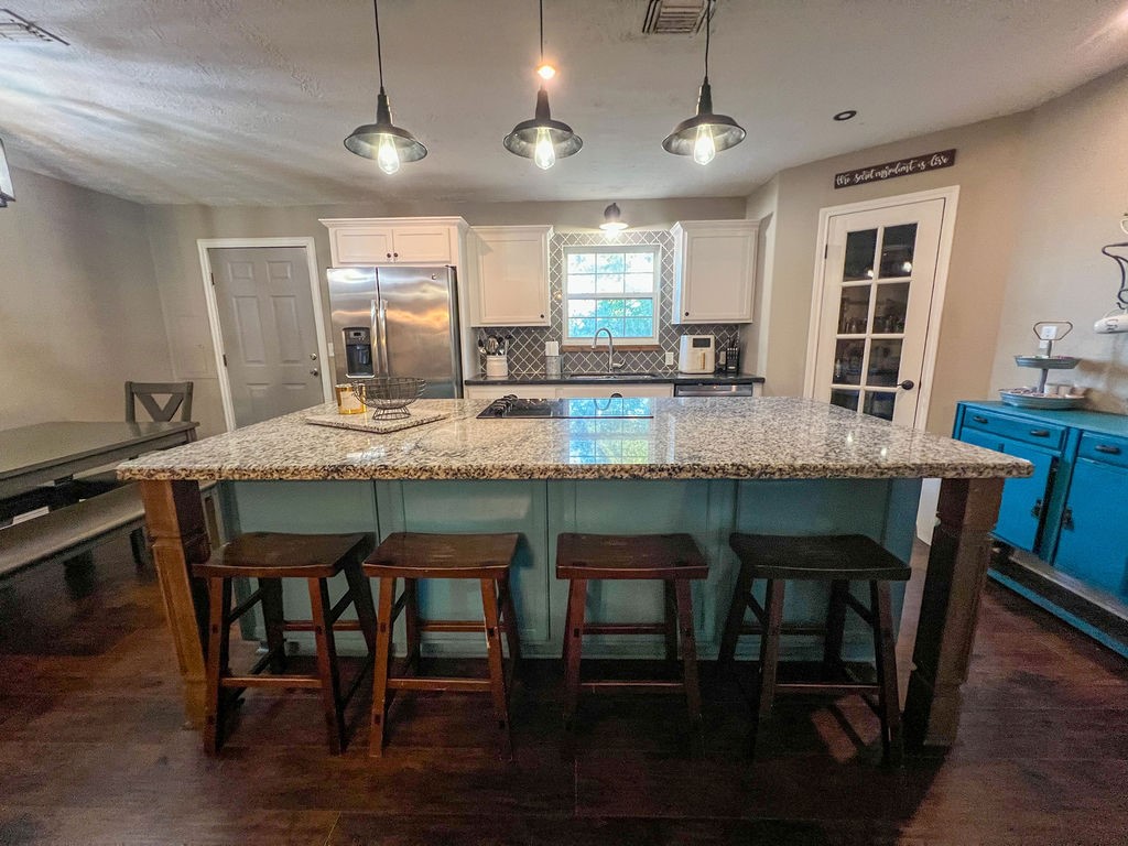29922 Hegar Road Hockley, TX 77447 - Photo 11 of 19 a kitchen with granite countertop a table chairs stove microwave and sink
