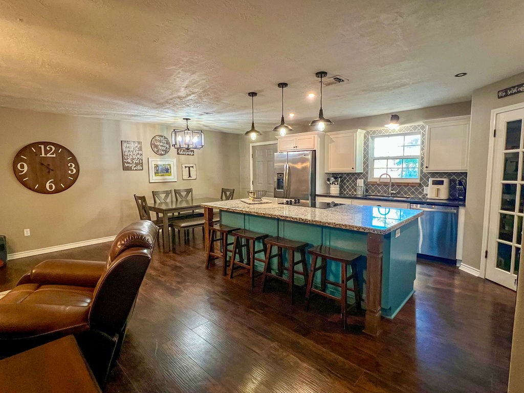 29922 Hegar Road Hockley, TX 77447 - Photo 6 of 19 a open kitchen with stainless steel appliances granite countertop a stove a sink a dining table and chairs