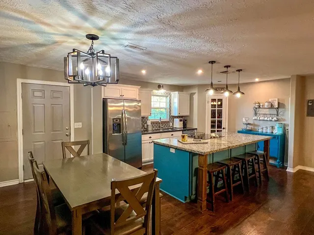 a kitchen with stainless steel appliances granite countertop a refrigerator a stove and a sink