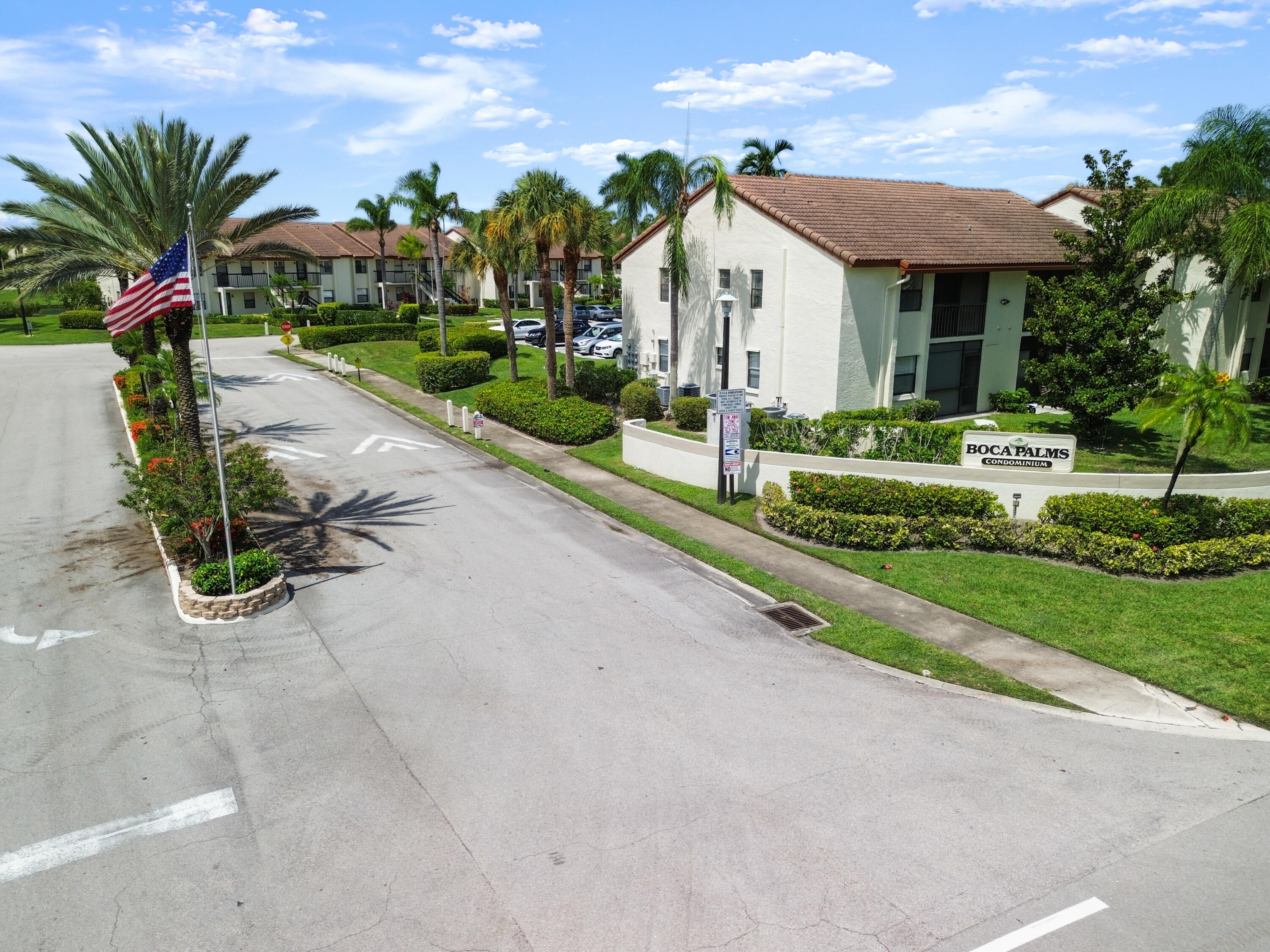 22076 Palms Way, Unit 202 Boca Raton, FL 33433 - Photo 3 of 35 a view of a house with a yard and potted plants