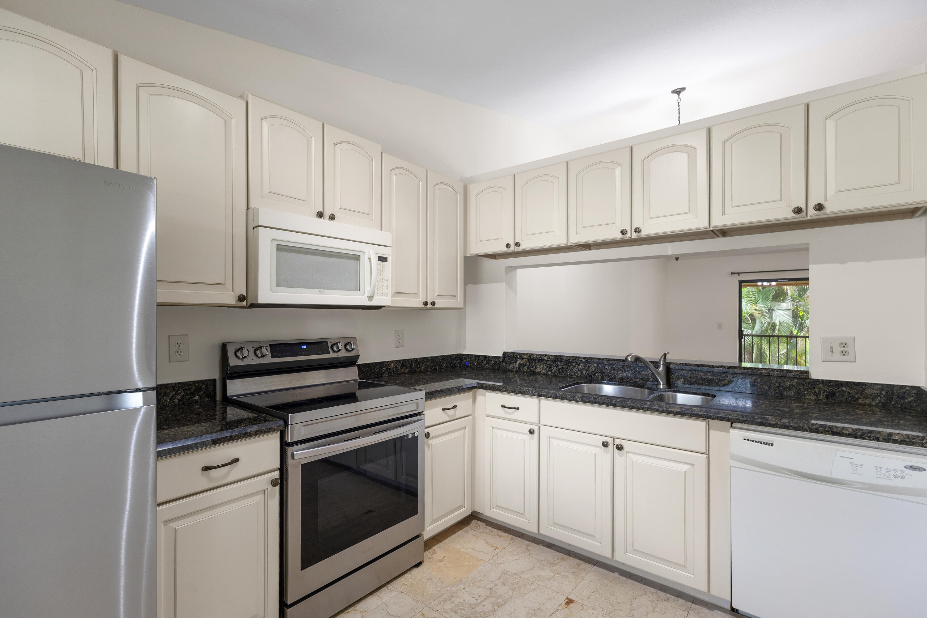 22076 Palms Way, Unit 202 Boca Raton, FL 33433 - Photo 6 of 35 a kitchen with granite countertop white cabinets white appliances and sink