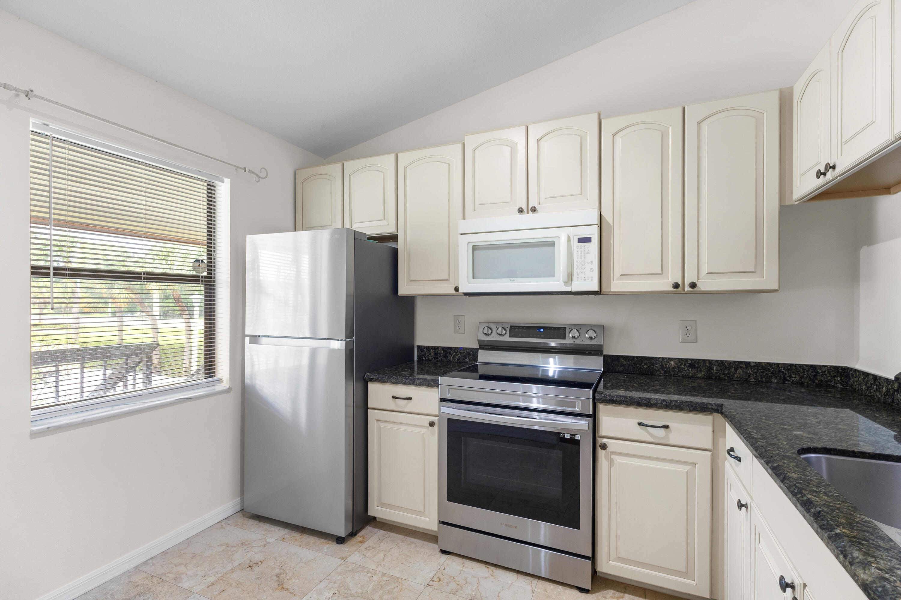 22076 Palms Way, Unit 202 Boca Raton, FL 33433 - Photo 7 of 35 a kitchen with cabinets stainless steel appliances and window