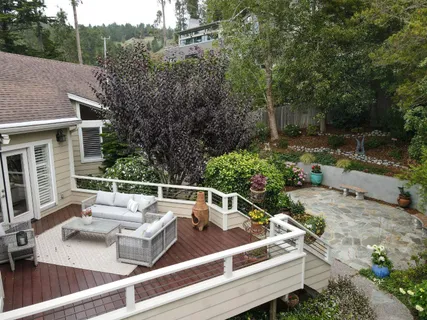 a view of a patio with couches table and chairs with wooden fence
