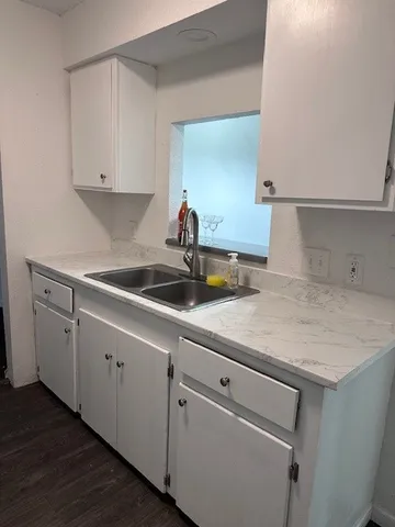 a kitchen with a sink cabinets and wooden floor