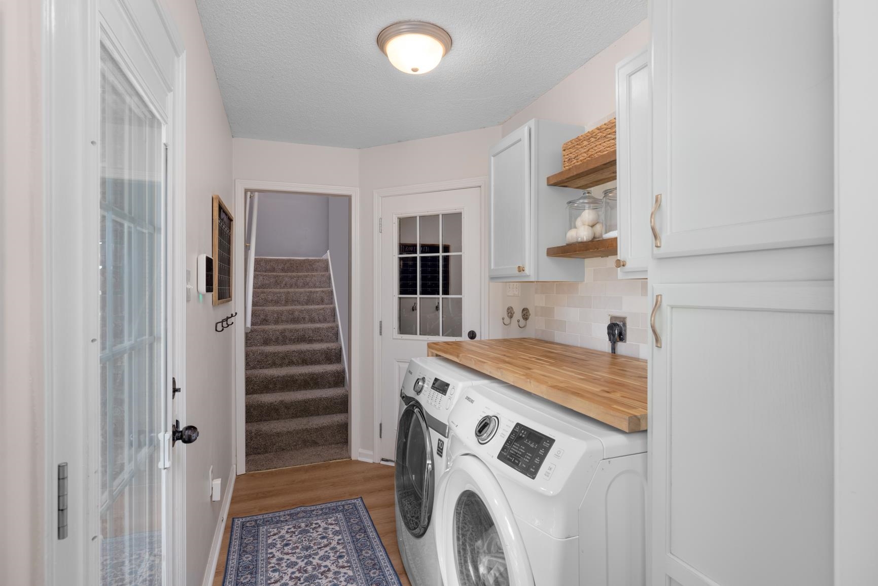 505 Terry Road Oakland, TN 38060 - Photo 33 of 40 Washroom featuring light wood finished floors, a textured ceiling, cabinet space, and washer and clothes dryer