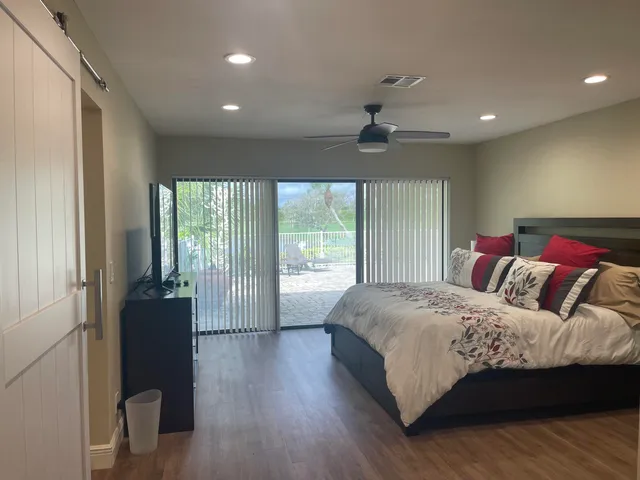 a bedroom with a large bed and wooden floor