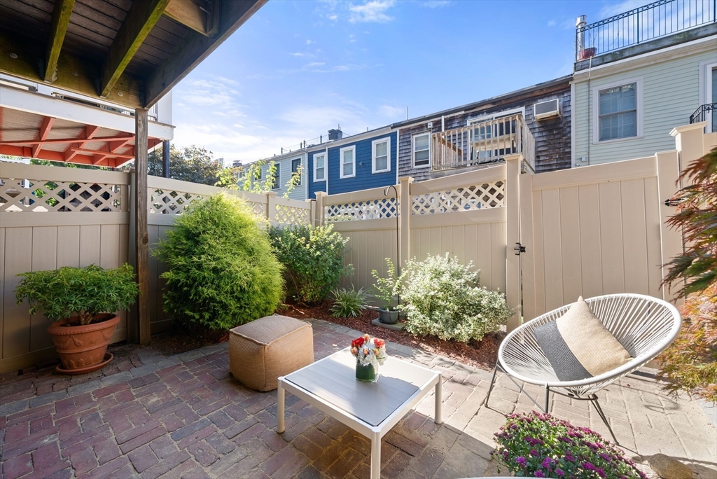 11 Wall Street Boston, MA 02129 - Photo 4 of 33 a backyard of a house with table and chairs potted plants