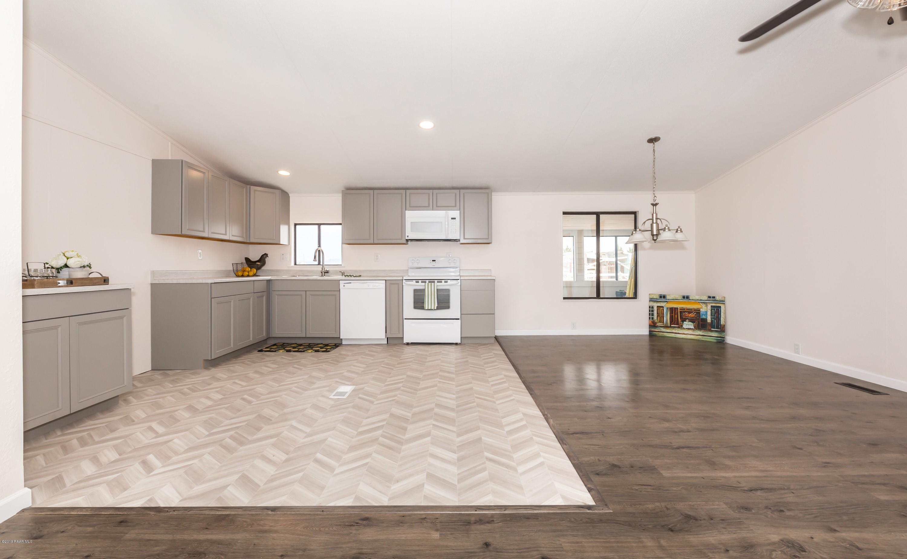 25156 North Stump Road Paulden, AZ 86334 - Photo 6 of 17 a large white kitchen with cabinets and wooden floor