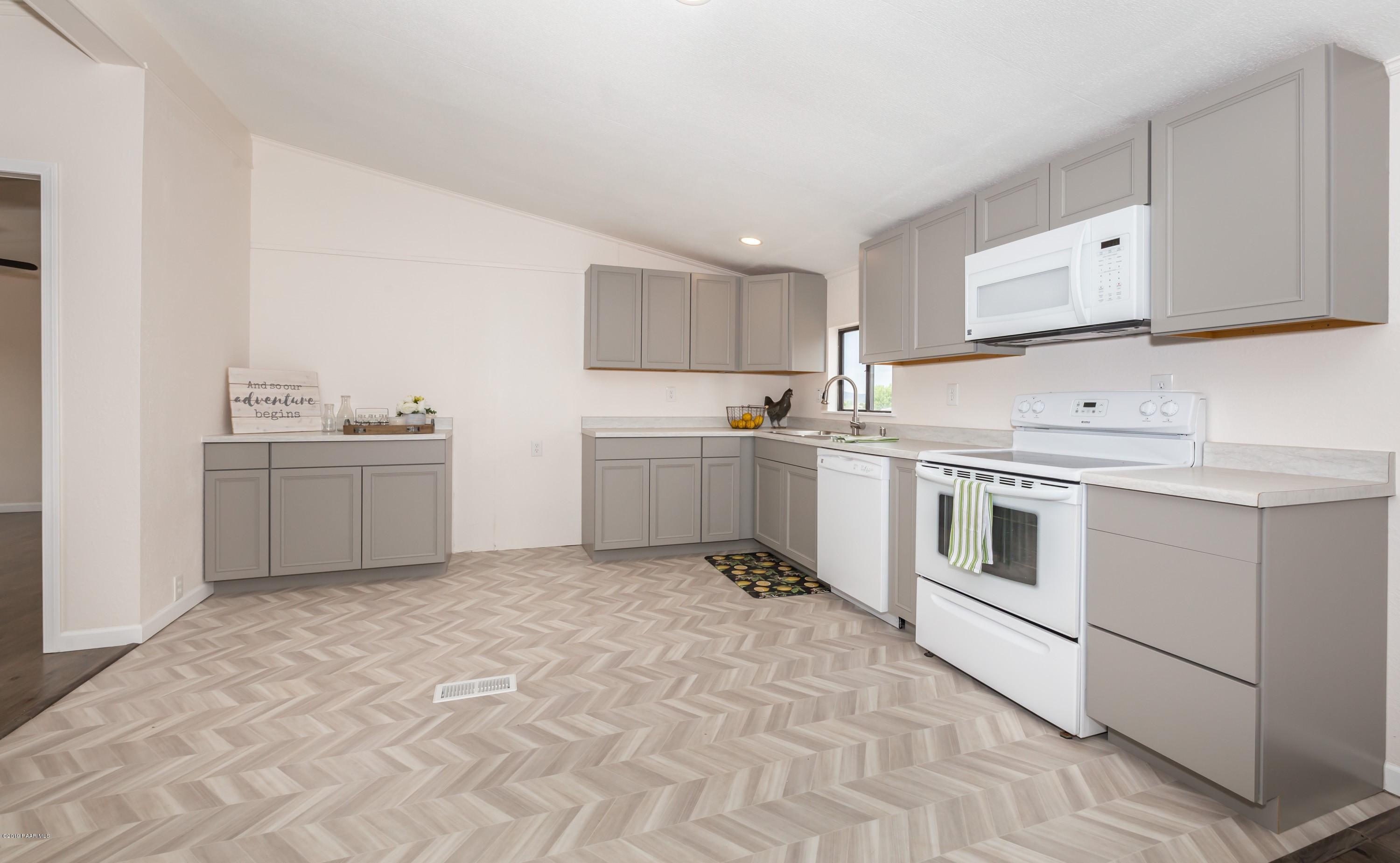 25156 North Stump Road Paulden, AZ 86334 - Photo 7 of 17 a kitchen with white cabinets and white appliances