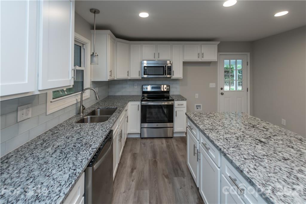 1060 Dunlap Roddey Road Rock Hill, SC 29730 - Photo 11 of 30 a kitchen with kitchen island granite countertop a sink stove and refrigerator