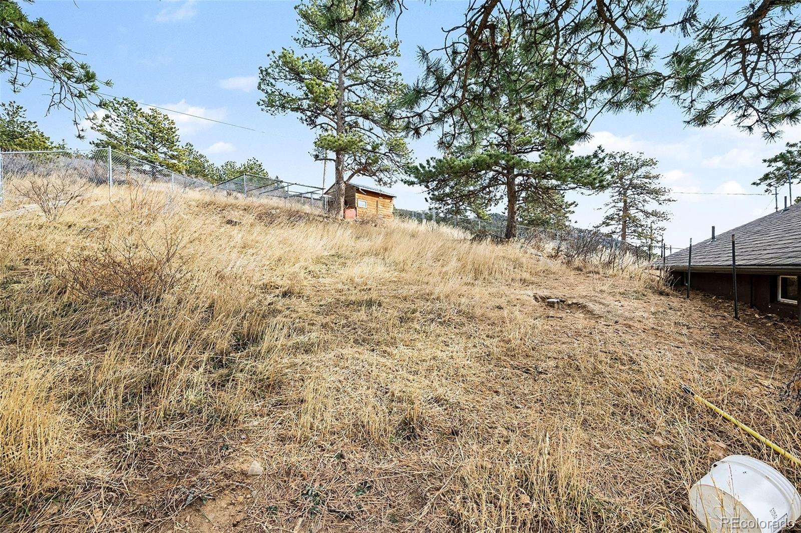6094 Pyrenees Trail Golden, CO 80403 - Photo 17 of 24 a view of a yard with wooden fence and a bench