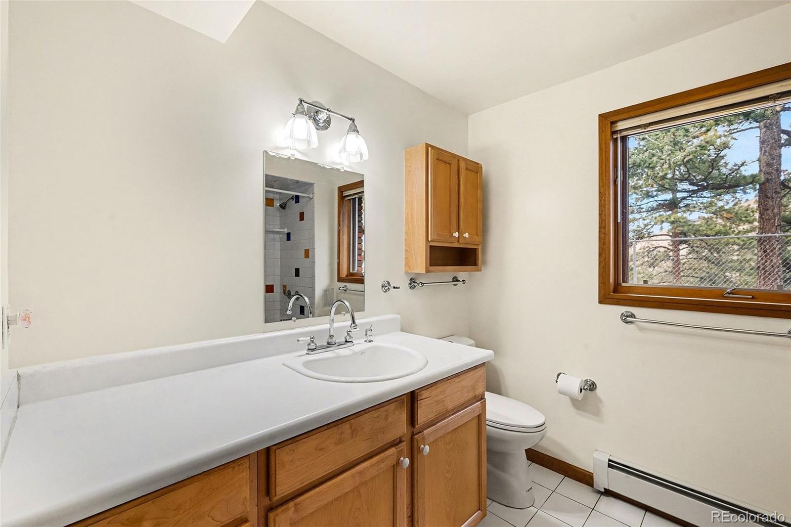 6094 Pyrenees Trail Golden, CO 80403 - Photo 7 of 24 a bathroom with a sink vanity and a mirror