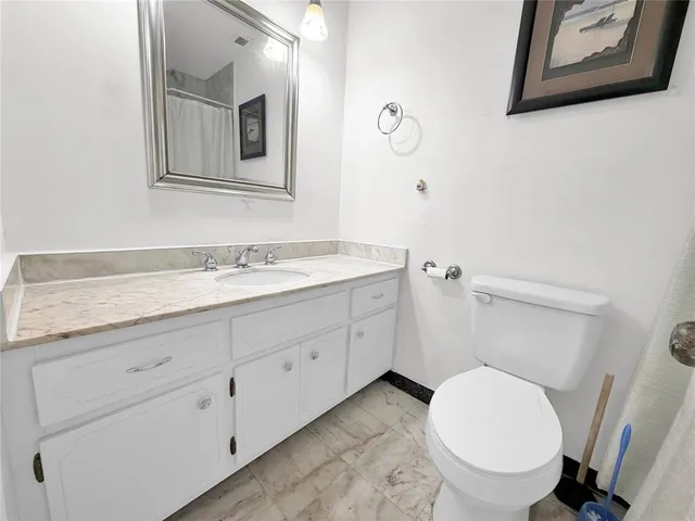a view of a hallway to a livingroom and a bathroom