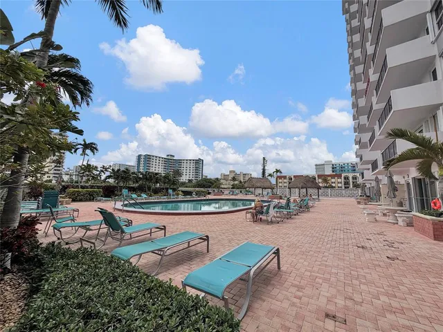 a swimming pool with outdoor seating and outdoor kitchen view