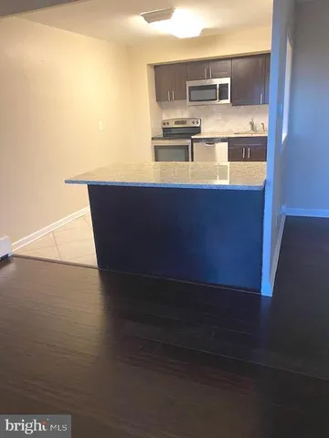 a view of kitchen with furniture and wooden floor