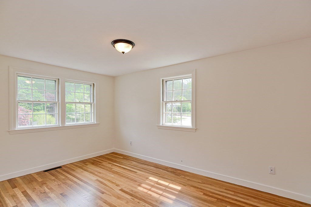 105 Booth Road Dedham, MA 02026 - Photo 27 of 39 a view of an empty room with wooden floor and a window