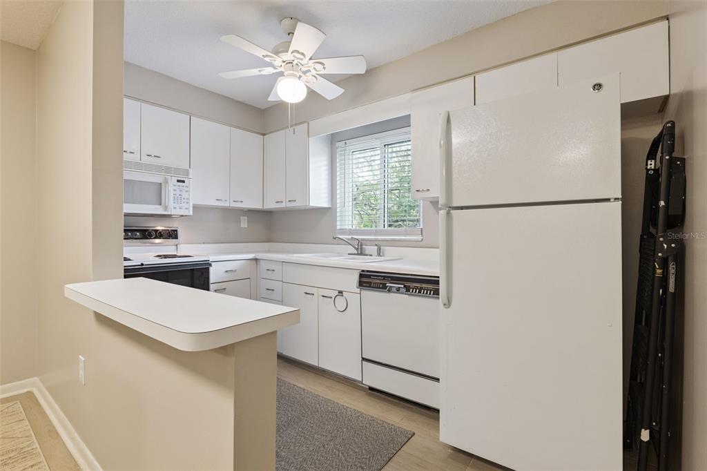525 South Conway Road, Unit 202 Orlando, FL 32807 - Photo 11 of 34 a kitchen with white cabinets and white appliances