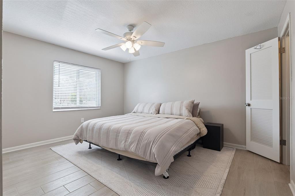 525 South Conway Road, Unit 202 Orlando, FL 32807 - Photo 13 of 34 a bedroom with a bed and a chandelier