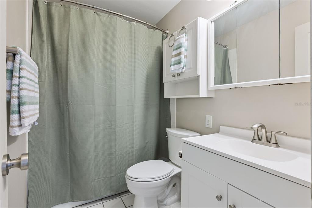 525 South Conway Road, Unit 202 Orlando, FL 32807 - Photo 17 of 34 a bathroom with a sink a toilet and shower curtain