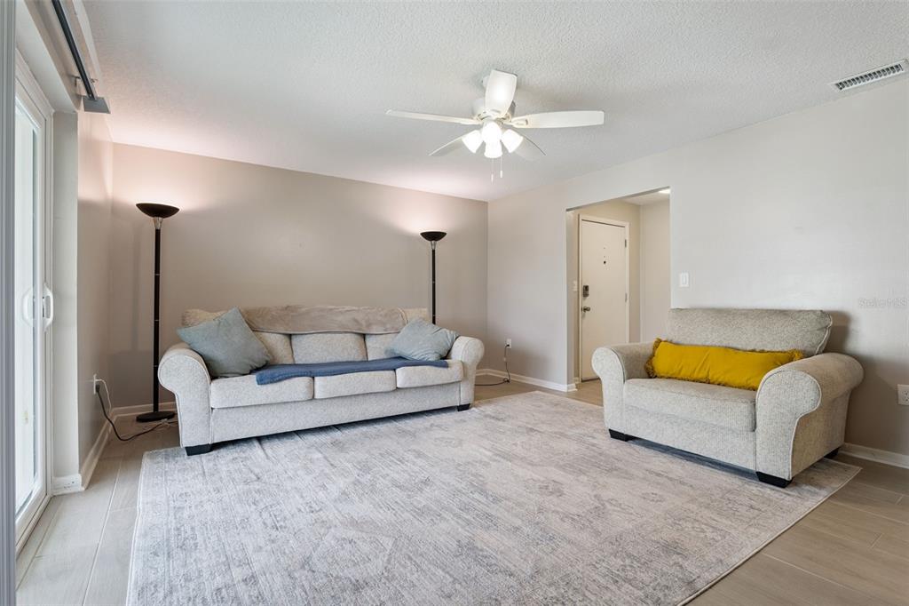 525 South Conway Road, Unit 202 Orlando, FL 32807 - Photo 5 of 34 a living room with furniture a ceiling fan and a rug