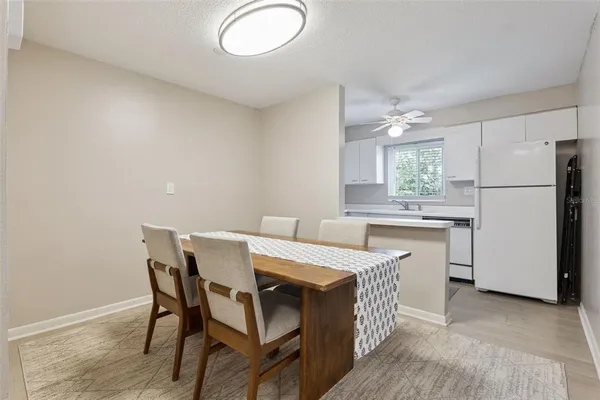a kitchen with a table chairs refrigerator and cabinets
