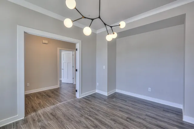 a living room with furniture kitchen view and a wooden floor