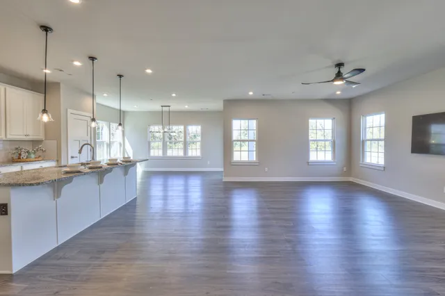 a large kitchen with granite countertop a large counter top stainless steel appliances and cabinets