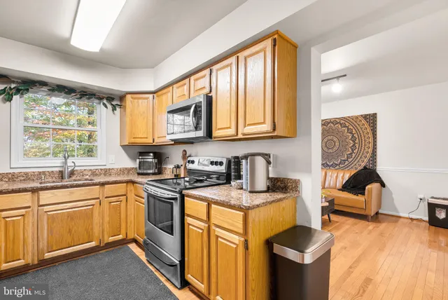a kitchen with granite countertop a sink stove and cabinets