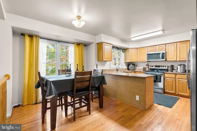 a kitchen with a table chairs refrigerator and cabinets