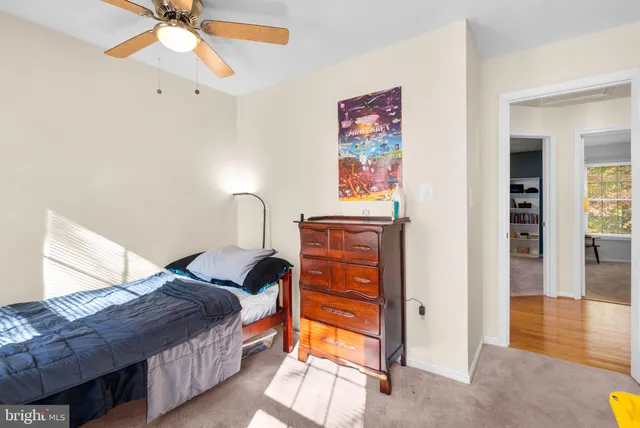 a bedroom with a bed bookshelf and a window