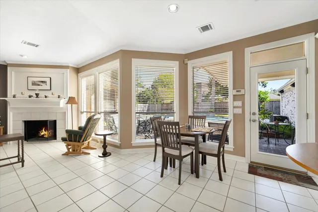 a view of a livingroom with furniture a fireplace and large windows