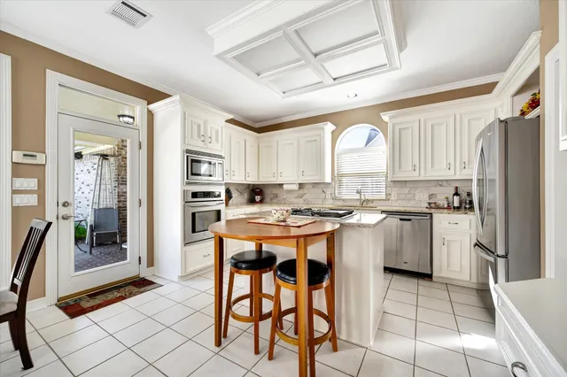 a kitchen with a refrigerator a stove a sink and cabinets