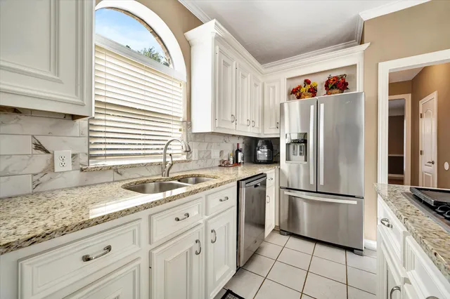 a kitchen with granite countertop a sink appliances and cabinets