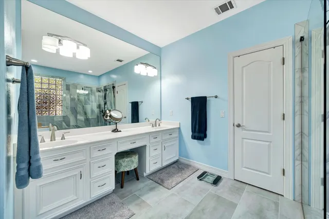 a spacious bathroom with a double vanity sink a large mirror next to a window