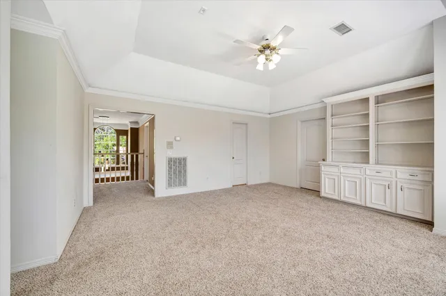 a view of an empty room with cabinet and a window
