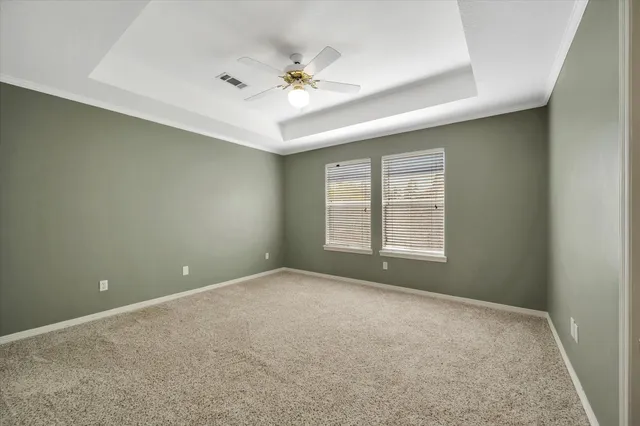 a view of an empty room with chandelier fan and fire place