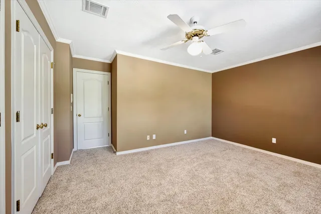 an empty room with closet and a chandelier fan