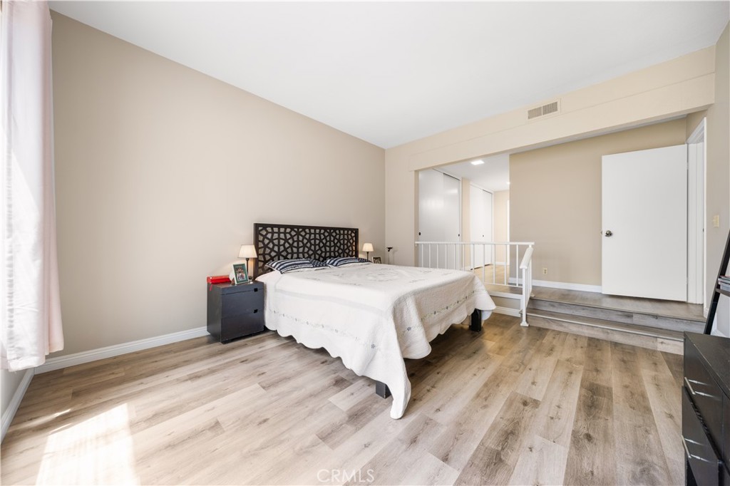 11 Palos, Unit 55 Irvine, CA 92612 - Photo 18 of 25 a bedroom with a bed and wooden floor