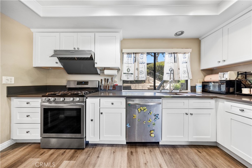 11 Palos, Unit 55 Irvine, CA 92612 - Photo 8 of 25 a kitchen with stainless steel appliances a stove a sink and a microwave