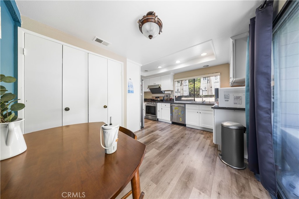 11 Palos, Unit 55 Irvine, CA 92612 - Photo 10 of 25 a kitchen with stainless steel appliances granite countertop a stove top oven a sink dishwasher and a refrigerator with wooden floor