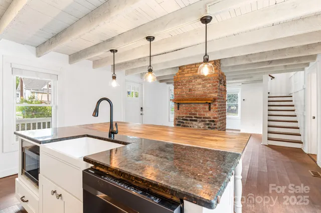 a kitchen with stainless steel appliances granite countertop a sink a stove and a wooden floors